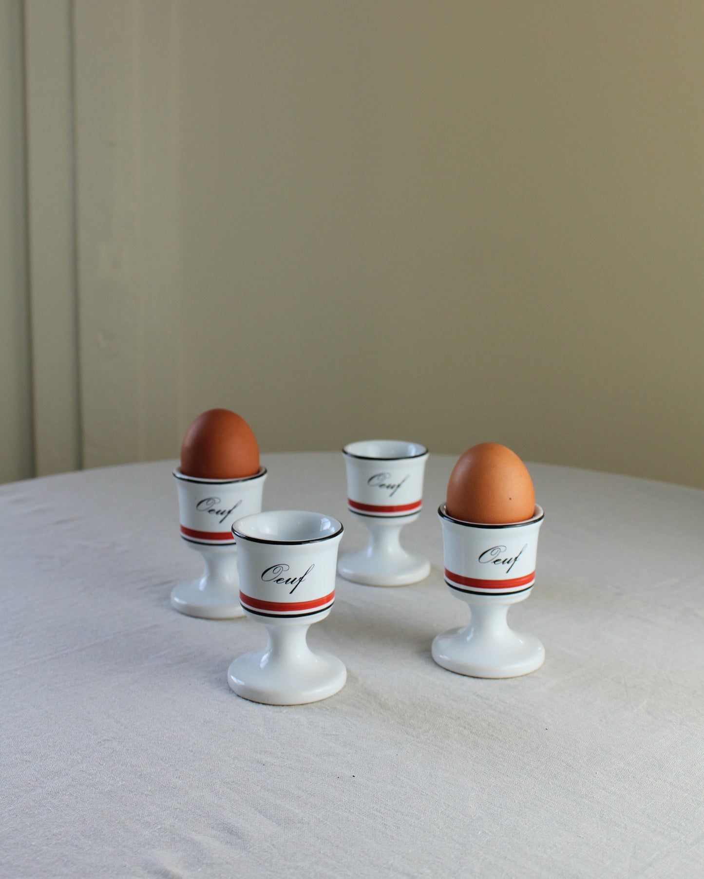 5 20th Century French ceramic white egg cups, black and red striped