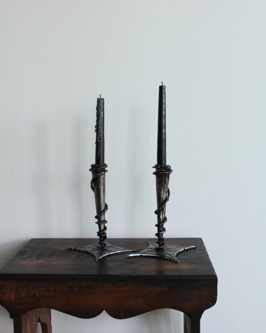 Decorative candle holders on a wooden table with a plain background