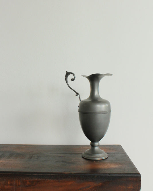 Decorative urn on a wooden surface with a plain background