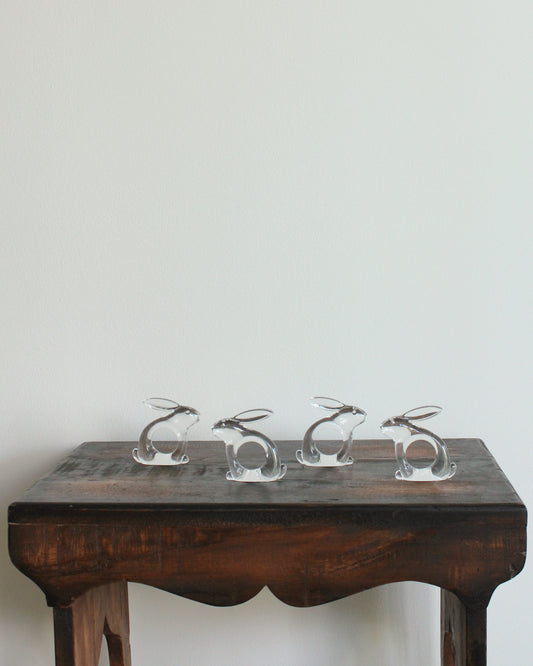 Rabbit lucite napkin rings on a wooden table
